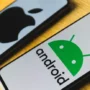 Two smartphones on a table—one showing the Android logo, the other the Apple logo—illustrating a comparison between iOS and Android security.
