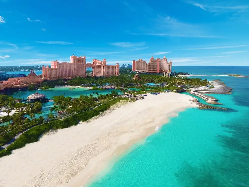 Aerial view of Atlantis Paradise Island resort with white sand beach and turquoise water in Nassau, Bahamas.