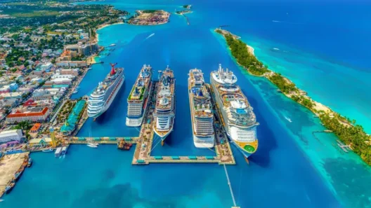 Aerial view of Nassau cruise port in the Bahamas with multiple docked ships, turquoise water, and nearby Paradise Island on a sunny day.