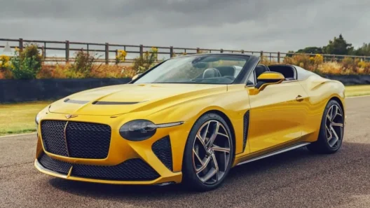 Bright yellow Bentley Mulliner Bacalar convertible on a racetrack, showcasing its sleek, roofless design and luxury craftsmanship; one of only 12 ever built.