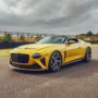 Bright yellow Bentley Mulliner Bacalar convertible on a racetrack, showcasing its sleek, roofless design and luxury craftsmanship; one of only 12 ever built.