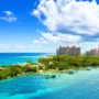 Aerial view of Atlantis Paradise Island resort surrounded by turquoise waters and lush greenery in the Bahamas under a bright blue sky
