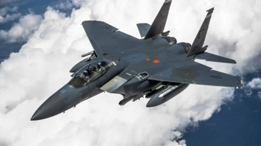 Modern Boeing F-15EX Eagle II fighter jet flying above the clouds during a high-altitude mission – showcasing its twin engines and weapon loadout.