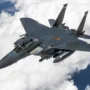 Modern Boeing F-15EX Eagle II fighter jet flying above the clouds during a high-altitude mission – showcasing its twin engines and weapon loadout.