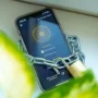 Smartphone displaying the CyberGhost VPN app connected to a Paris server, wrapped in a chain with a padlock to symbolize a secure, protected connection.