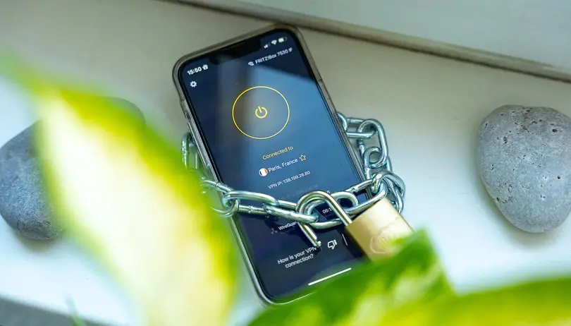 Smartphone displaying the CyberGhost VPN app connected to a Paris server, wrapped in a chain with a padlock to symbolize a secure, protected connection.