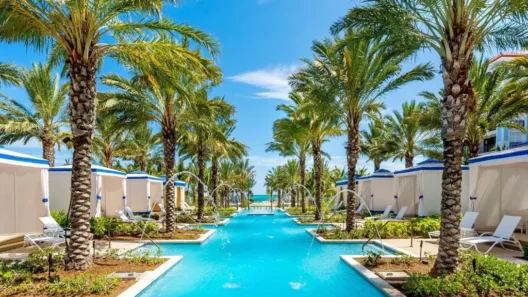 Elegant pool canal lined with palm trees and private cabanas at Grand Hyatt Baha Mar, leading toward the ocean.
