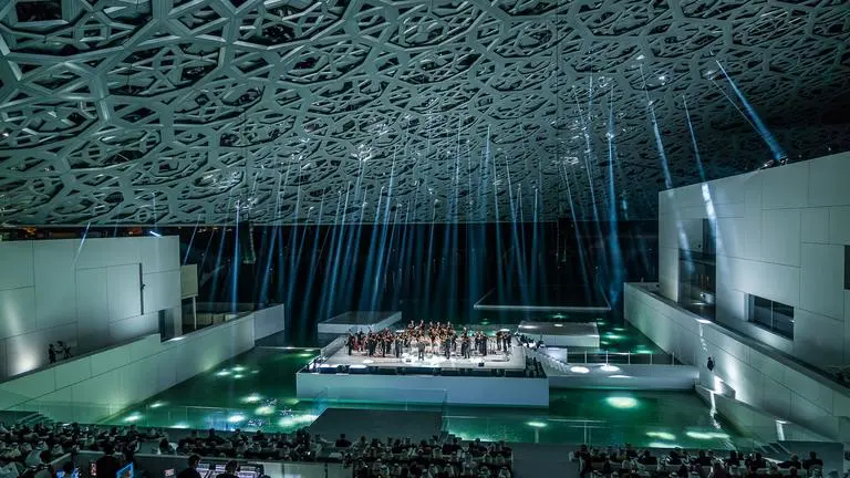 Live music and culture come together under the glowing dome during a night event at Louvre Abu Dhabi.