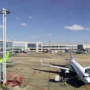 Commercial airplanes parked at the gate at Praia Airport (RAI) in Cape Verde, with the terminal building and control tower visible under a clear blue sky.