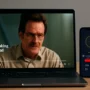 A laptop streaming Netflix while connected to CyberGhost VPN, with a smartphone, tablet, and TV in the background – all devices running the VPN simultaneously.