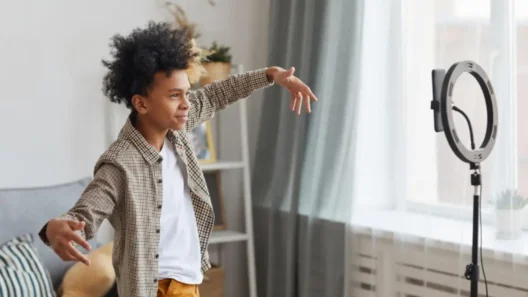 A young boy recording a TikTok dance video at home using a smartphone and ring light, highlighting children’s active use of social media platforms.
