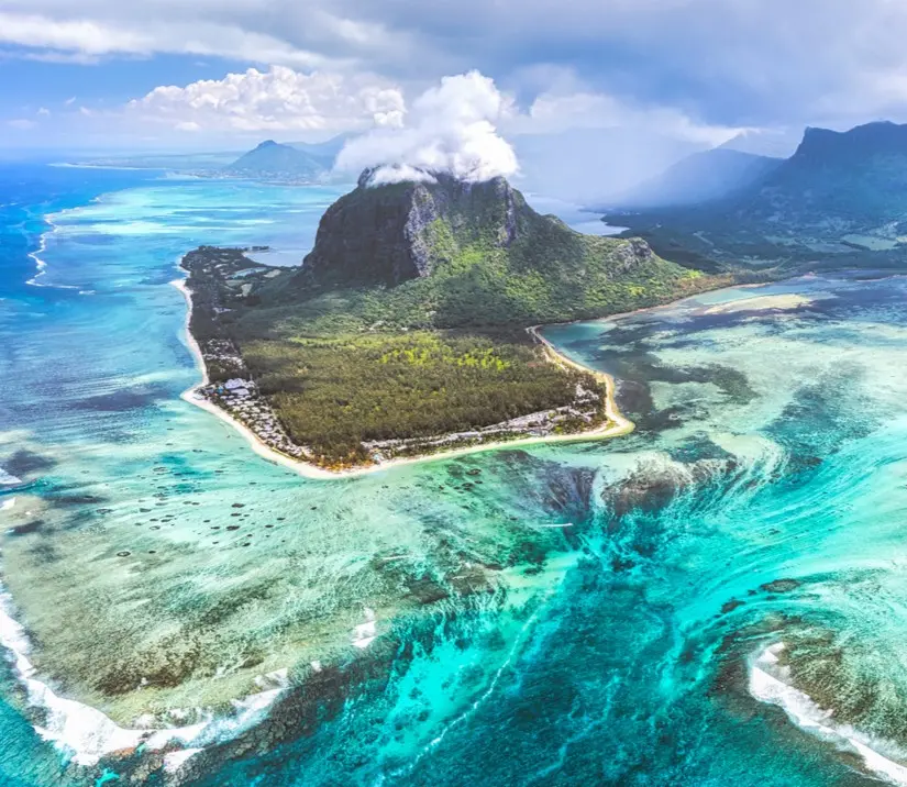 Aerial view of Le Morne Brabant in Mauritius showing the optical illusion of an underwater waterfall created by ocean floor sediment drop-off.