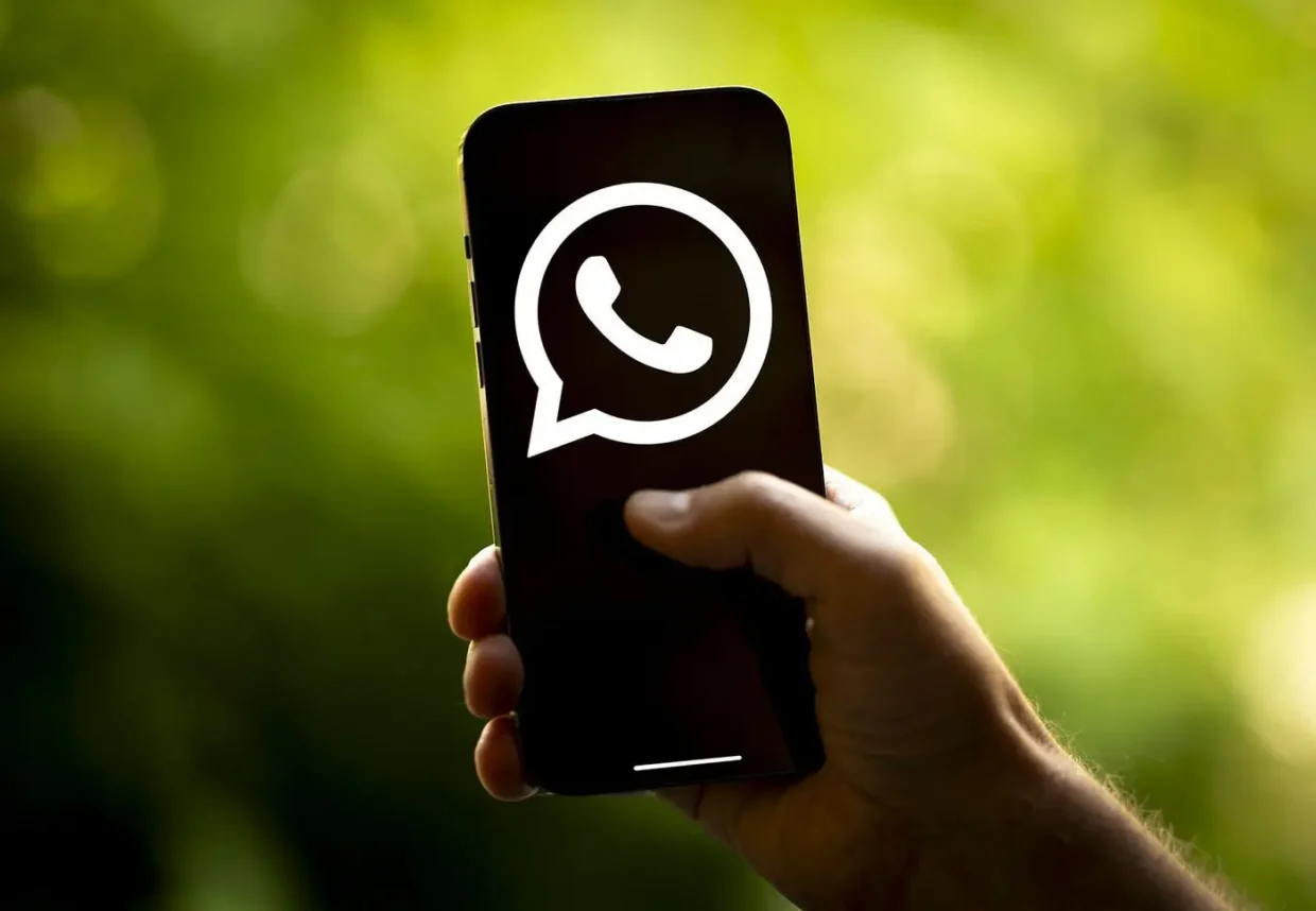 Hand holding a smartphone with large WhatsApp logo on screen, symbolizing blocked VoIP calls and the need for VPN access in countries like Egypt.