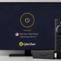 CyberGhost VPN connected on a Smart TV with New York server, showing a Firestick device and remote in front of the screen.