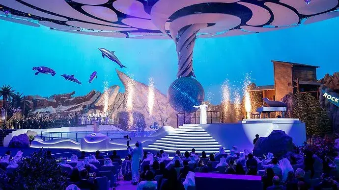 Live indoor performance at SeaWorld Abu Dhabi with dolphins, lights, and a large audience.