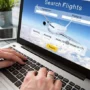 Person searching for flights online on a laptop, with a flight booking website open and hands typing on the keyboard, planning a trip and looking for the best ticket deals.