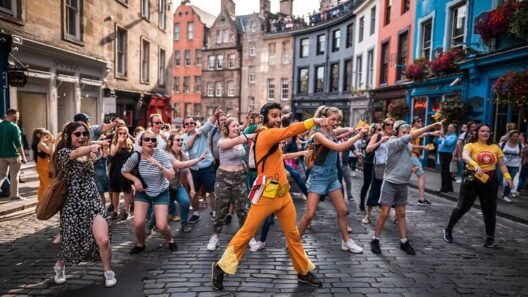 A group of people dancing in the street during the Edinburgh Fringe Festival in Scotland, led by a man in an orange costume, with a lively and joyful atmosphere in the historic city center.