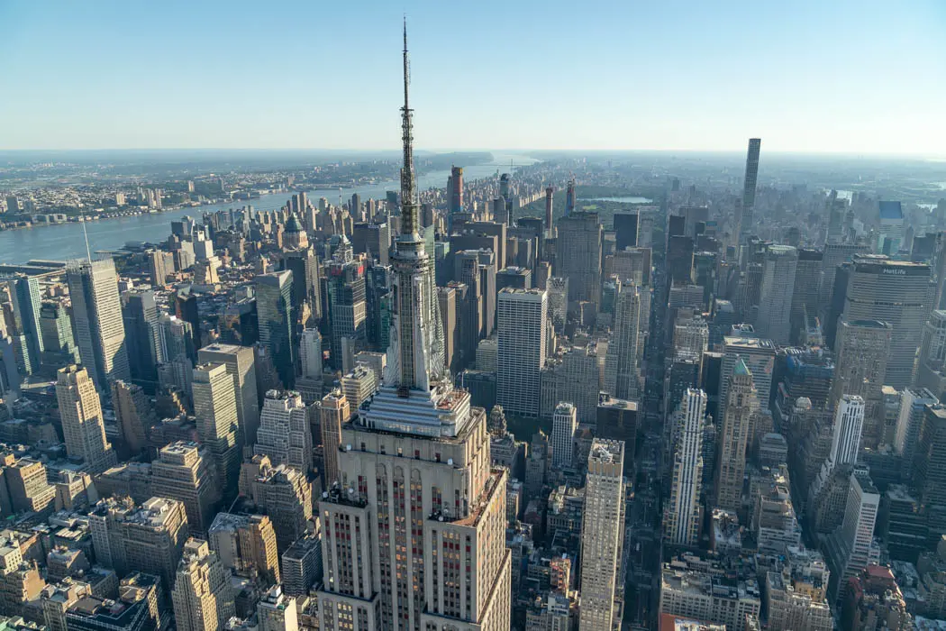 Aerial view of the Empire State Building and Midtown Manhattan skyline on a clear day in New York City.