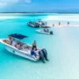 A boat excursion in the Bahamas: People enjoying a sunny day on a stunning sandbar surrounded by crystal-clear sea.
