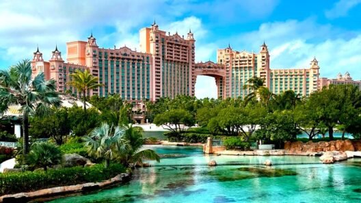 Atlantis Paradise Island resort with turquoise lagoon, lush palm trees, and tropical gardens in the Bahamas under a bright blue sky.