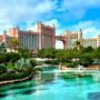 Atlantis Paradise Island resort with turquoise lagoon, lush palm trees, and tropical gardens in the Bahamas under a bright blue sky.