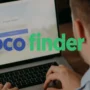 A man is using a laptop with the CocoFinder website on the screen. The CocoFinder logo is large and clear in the foreground, with nothing touching the image edges. The photo is in a bright, realistic style and 16:9 format.