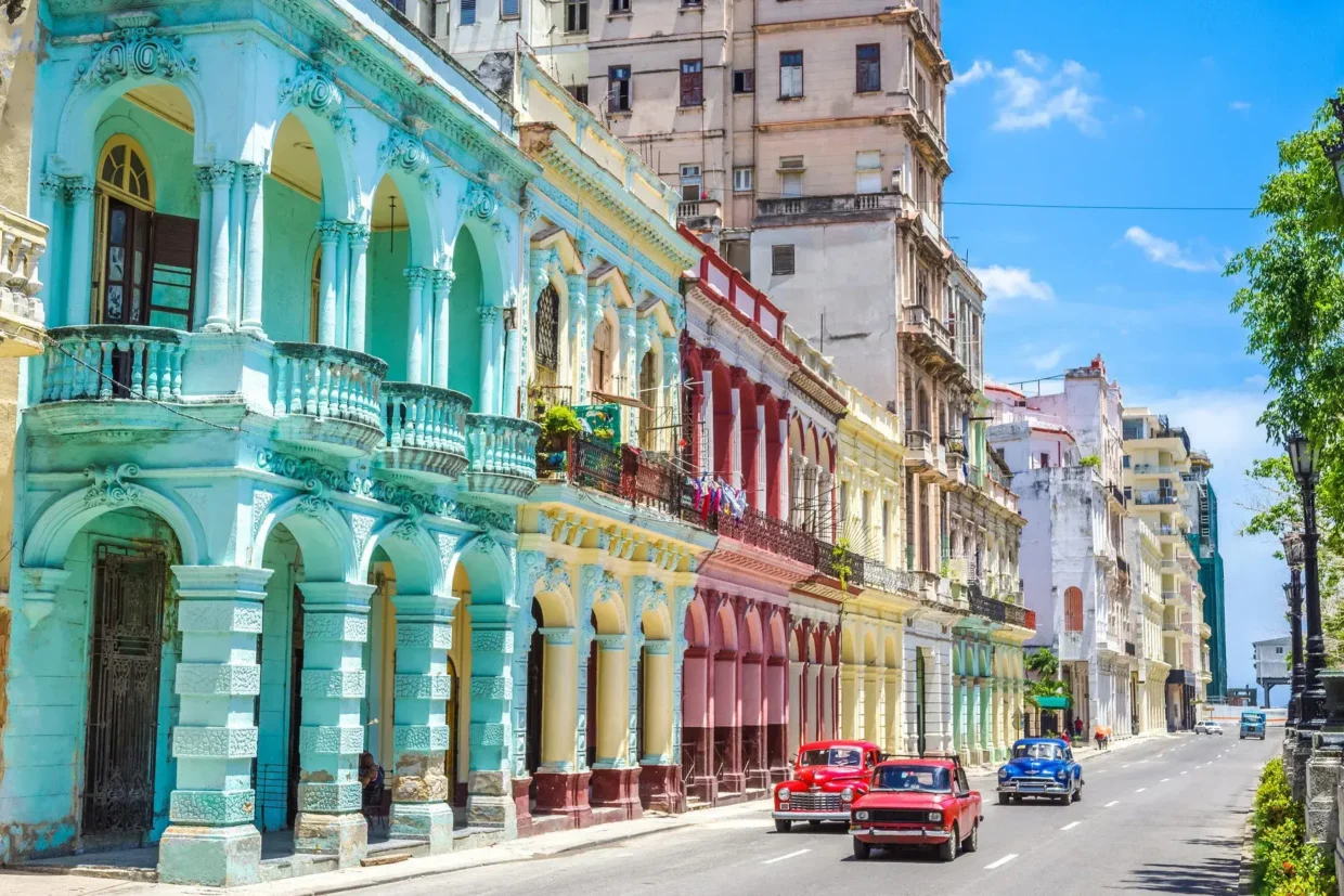 Colorful colonial buildings and classic American cars on a sunny street in Havana, Cuba
