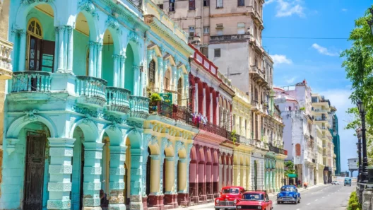Colorful colonial buildings and classic American cars on a sunny street in Havana, Cuba