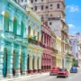 Colorful colonial buildings and classic American cars on a sunny street in Havana, Cuba