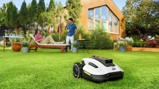 A robotic lawn mower automatically mowing a green backyard, while a woman relaxes on a sun lounger and a man enjoys a drink, with a modern house and lush garden in the background.