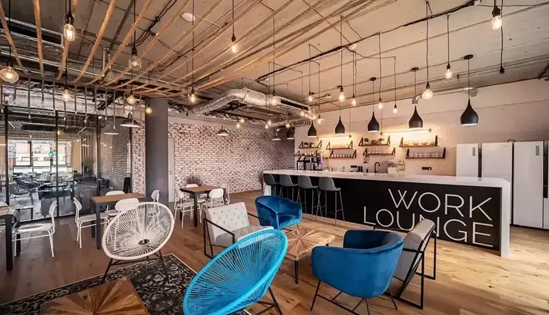 Modern coworking lounge in Prague, featuring stylish seating, a large bar, and bright open space—ideal for digital nomads seeking fast Wi-Fi, networking, and a comfortable remote work vibe.