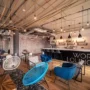 Modern coworking lounge in Prague, featuring stylish seating, a large bar, and bright open space—ideal for digital nomads seeking fast Wi-Fi, networking, and a comfortable remote work vibe.