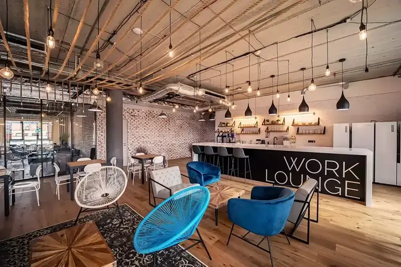 Modern coworking lounge in Prague, featuring stylish seating, a large bar, and bright open space—ideal for digital nomads seeking fast Wi-Fi, networking, and a comfortable remote work vibe.