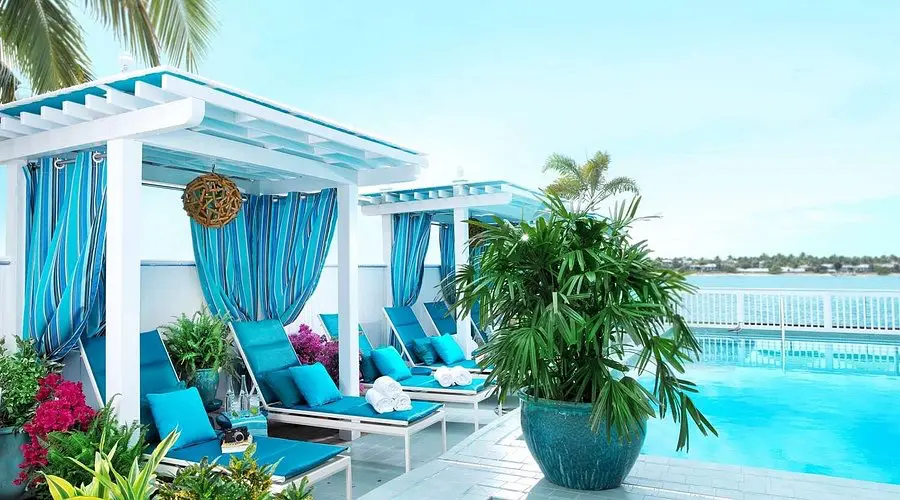 Stylish cabanas and turquoise loungers by the pool at Ocean Key Resort, overlooking the calm blue waters.