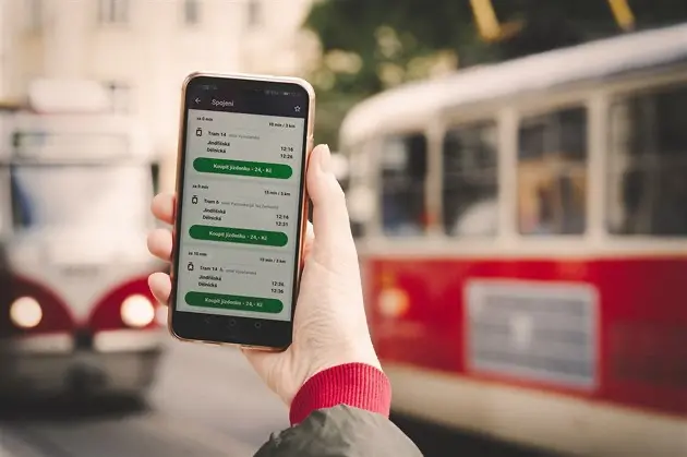 Hand holding a smartphone with the PID Lítačka app, showing digital tickets for Prague trams and metro.