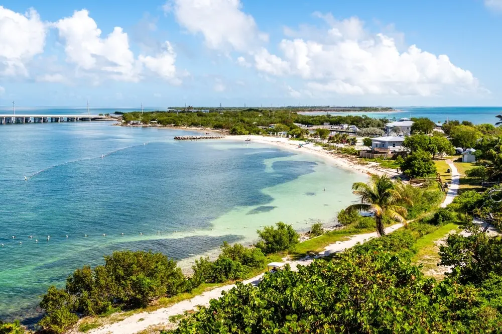 Scenic aerial view of Big Pine Key with shallow teal waters and lush green surroundings, home of the endangered Key deer.