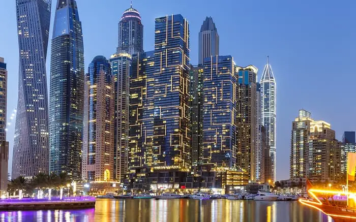 Iconic high-rise buildings illuminated in Dubai Marina, one of the top real estate zones for foreign investors.