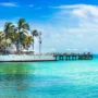 Historic white guesthouses and a palm-lined dock over turquoise water in Key West, capturing the tropical charm of the island.