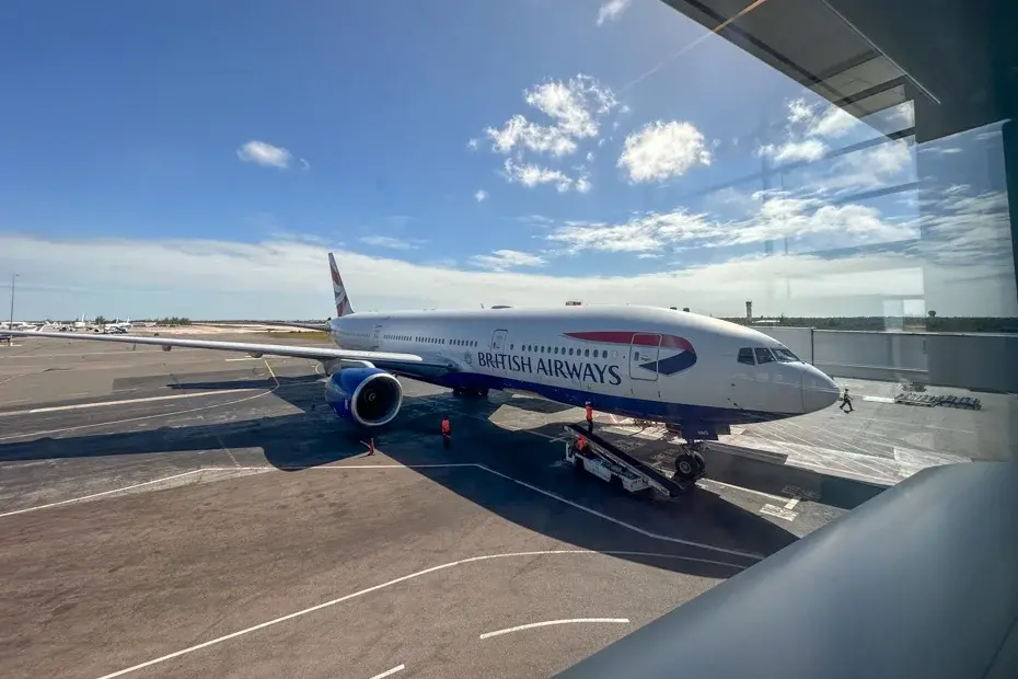 Nassau Airport Bahamas-2 | Venclikovi.com British Airways plane parked at Nassau Airport in the Bahamas under a sunny sky, viewed from inside the terminal with ground crew nearby.