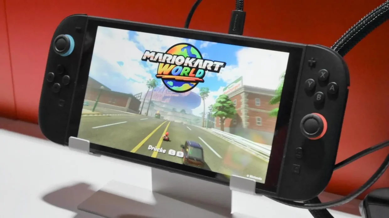 Nintendo Switch 2 running Mario Kart World in handheld mode on a bright screen, showing Mario racing down a city road.