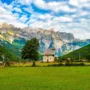 Scenic view of Thethi Church in Albania with the Accursed Mountains in the background on a sunny day