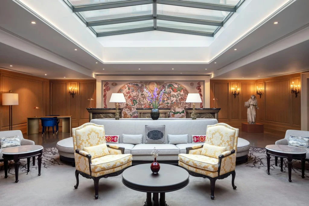 Augustine a Luxury Collection Hotel Prague 2 | Venclikovi.com Elegant lobby at Augustine, a Luxury Collection Hotel, Prague, with skylight ceiling, antique furniture, and monastic-inspired decor.