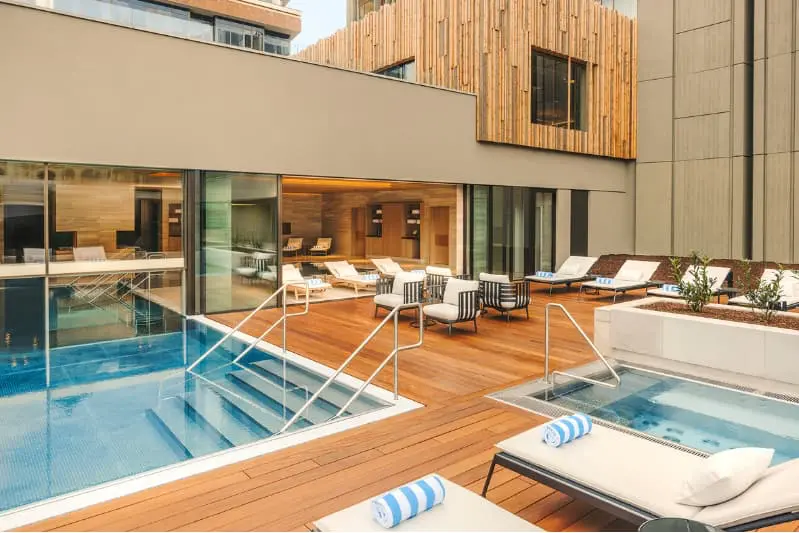 Fairmont Golden Prague wellness | Venclikovi.com Fairmont Golden Prague rooftop wellness area with outdoor pool, sun loungers, and modern spa design.