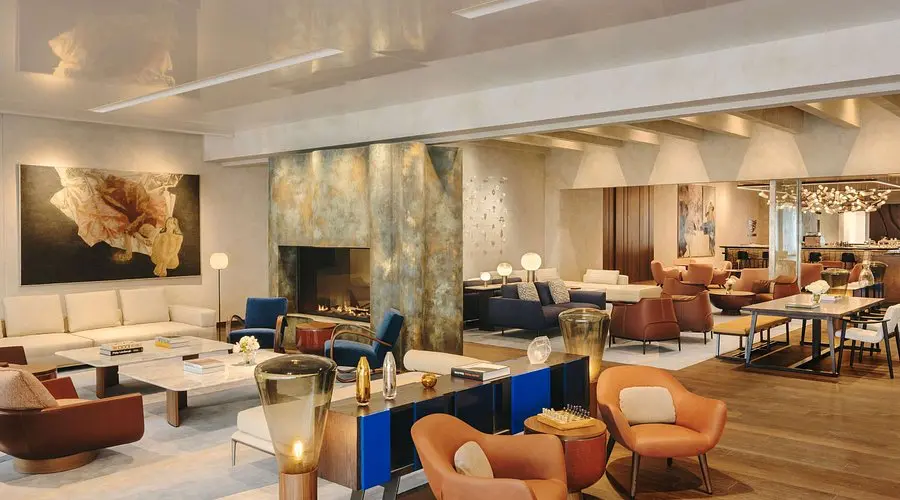 Fairmont Golden Prague | Venclikovi.com Elegant lounge at Fairmont Golden Prague with designer furniture, fireplace, and artistic décor.