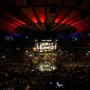 Packed Madison Square Garden arena with UFC octagon lit up and fans watching live fight