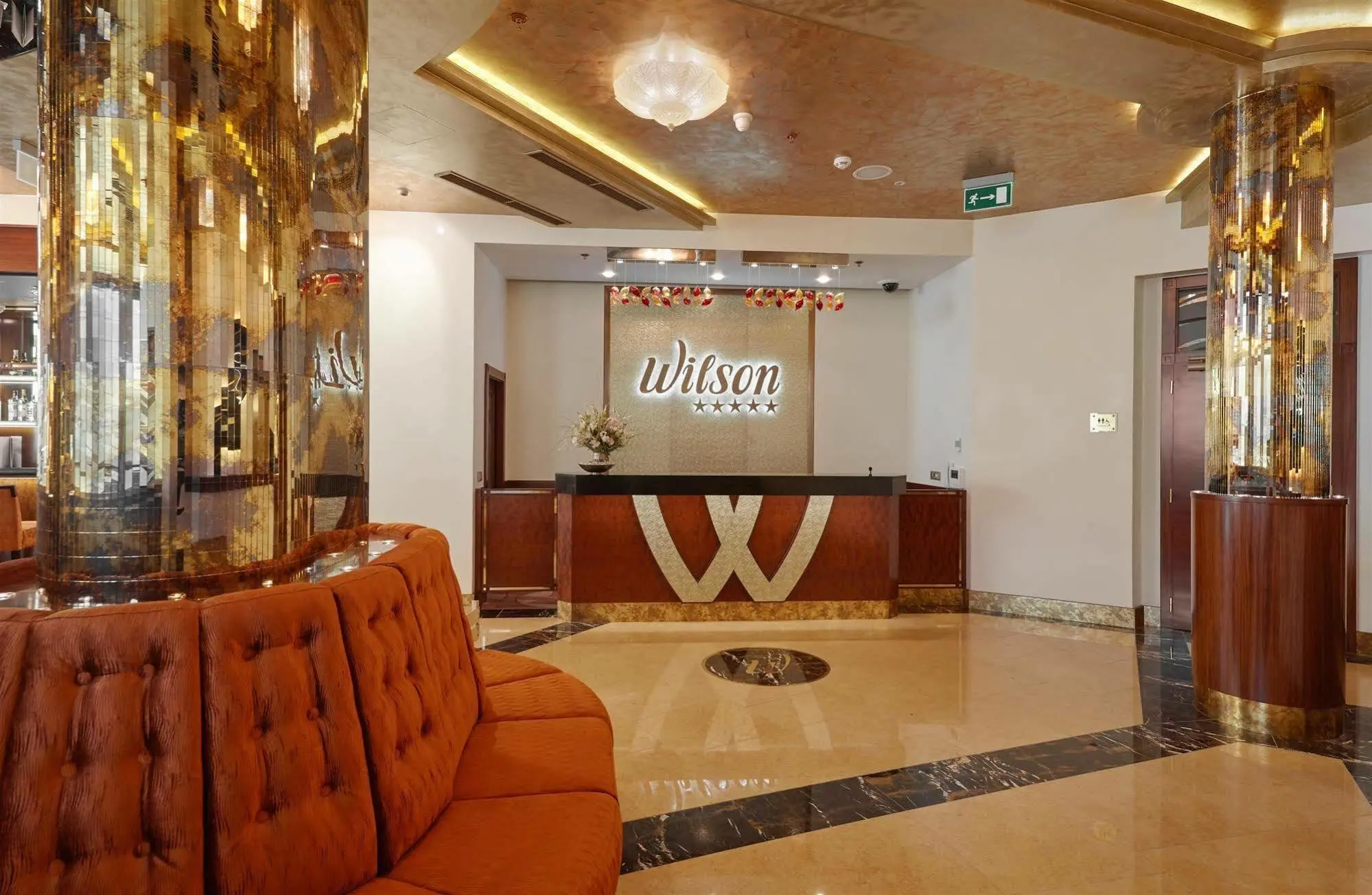 Occidental Praha Wilson | Venclikovi.com Elegant lobby of Occidental Praha Wilson with golden tones and modern reception in central Prague.