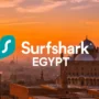 Surfshark logo over Cairo skyline at dusk with palm trees and the Nile River in the background – visualizing VPN connection in Egypt.