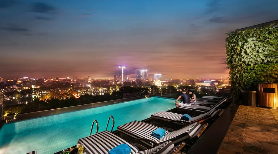 THE ORIENTAL JADE HOTEL HAnoi Vietnam | Venclikovi.com Oriental Jade Hotel rooftop infinity pool overlooking Hanoi’s skyline during sunset.