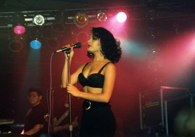 selena-quintanilla-black-bra-top-live-show | Venclikovi.com Selena Quintanilla performing live in her signature black bra top, under vibrant stage lights during one of her unforgettable Tejano shows.