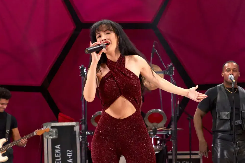 selena-quintanilla-live-astrodome-signature-look | Venclikovi.com Selena Quintanilla singing live in her iconic burgundy jumpsuit, capturing the energy and spirit of her unforgettable Astrodome performance.